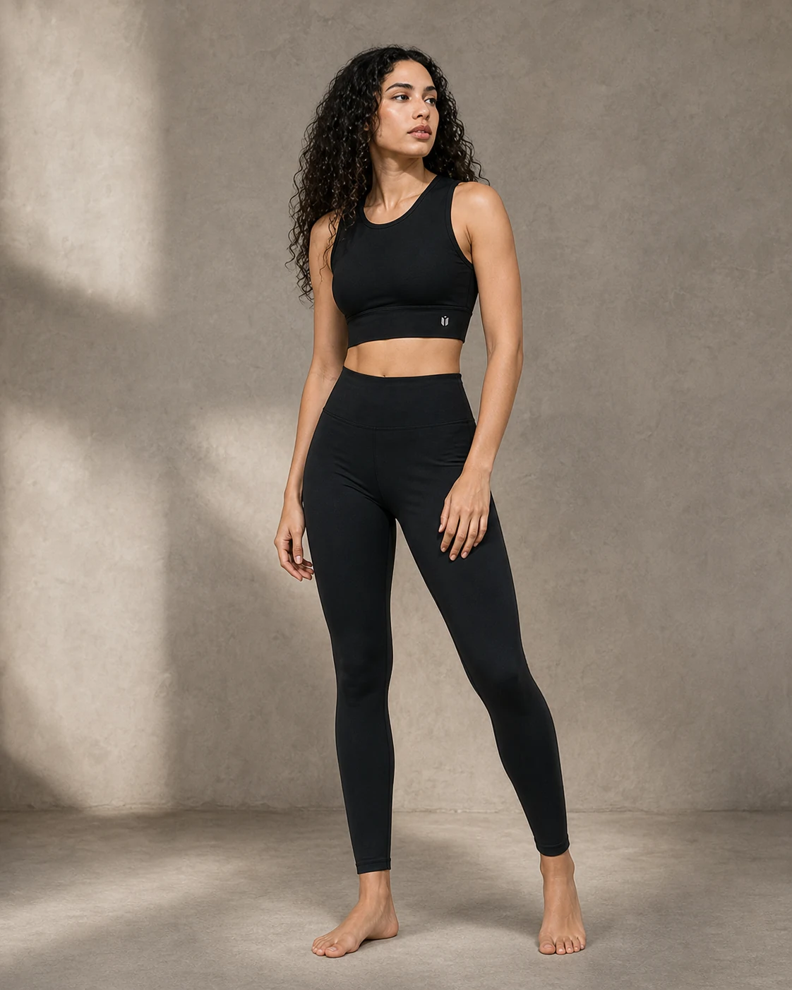 Sharp portrait of a model wearing the YellowCrop black Sports Bra and active bottom set